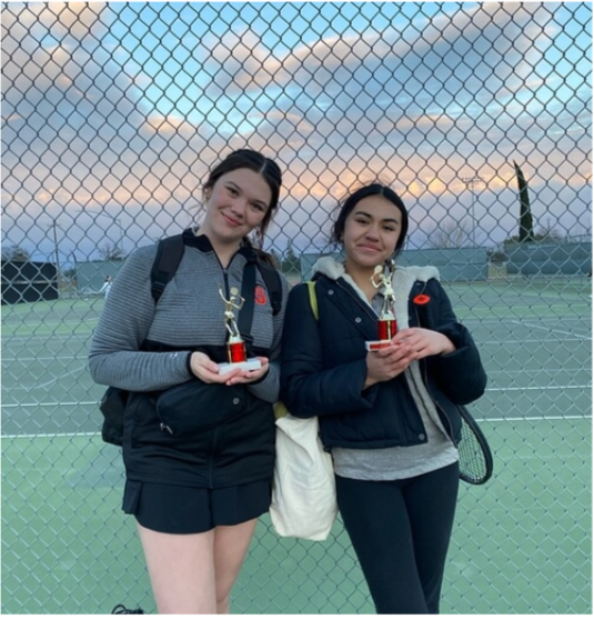 Caption, Annika Cardinal (on the right) and Elise Mendezona (on the left) posing with their first place trophies from the River Bank Tournament.